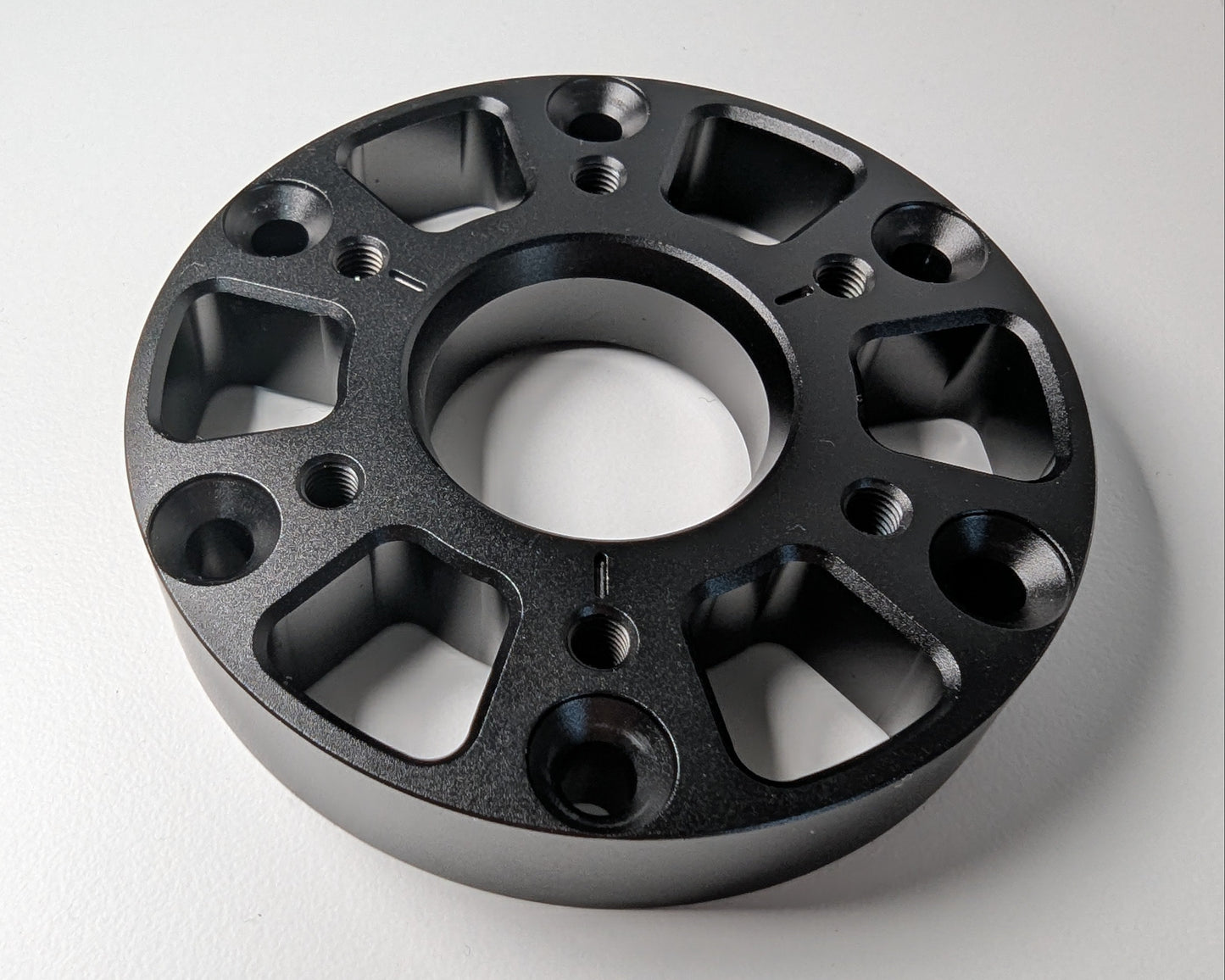 A photo of the main face of the 50 to 70 mm adapter showing all mounting options. On a white surface