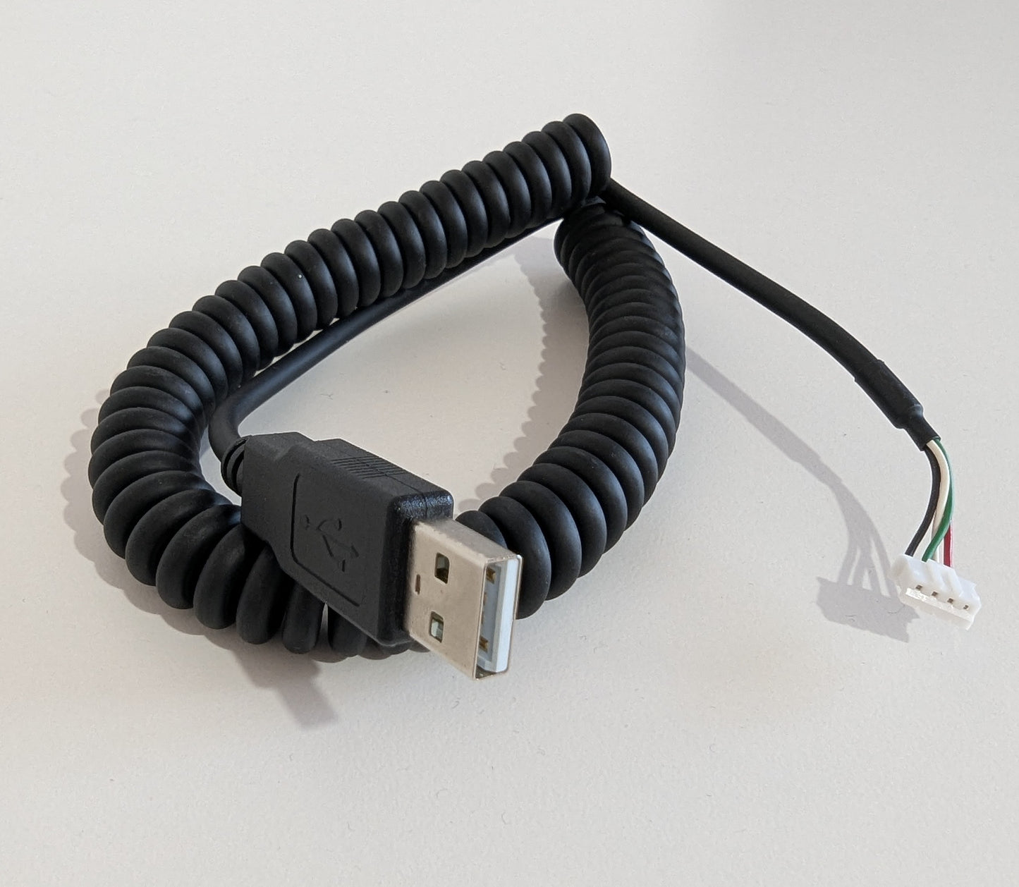 Coiled USB cable on a light gray background