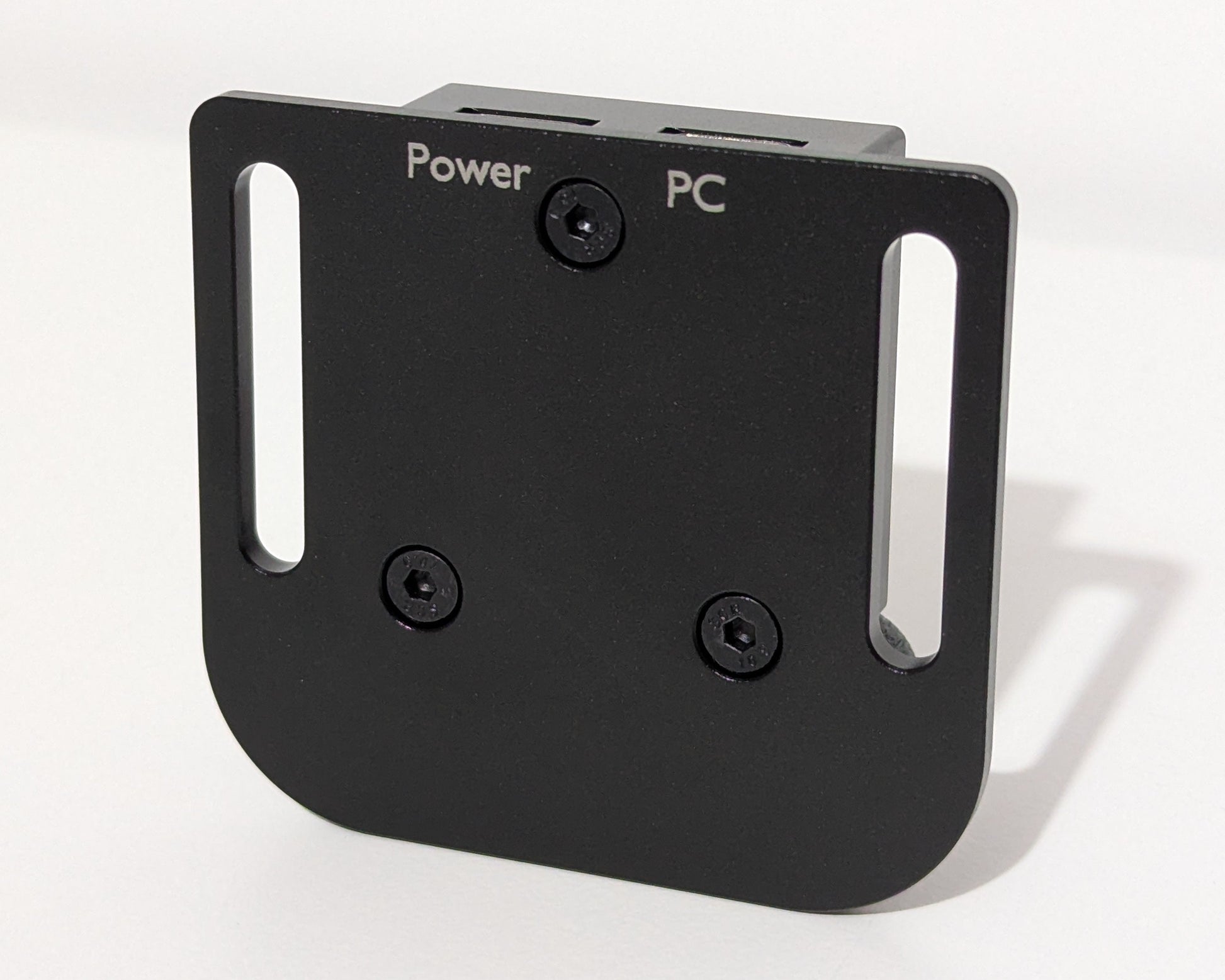 An image showing the underside of a small black device. The words Power and PC are engraved in the finish to indicate which port is used for which connection for the JCSS USB Power Injector