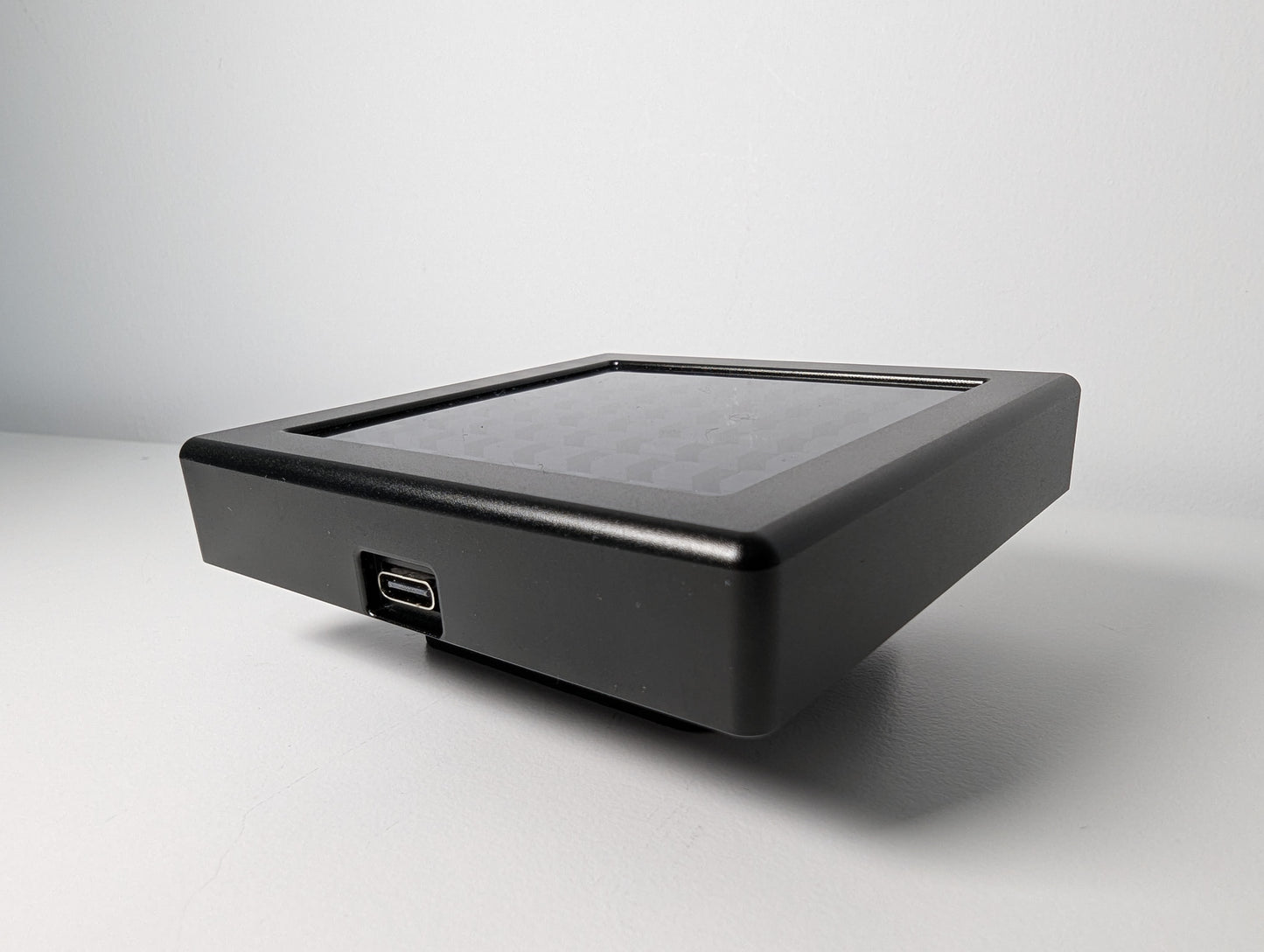 A photo of the JC Sim Flag laid down resting on it's bracket on a white surface. The LED panel is shown face up.