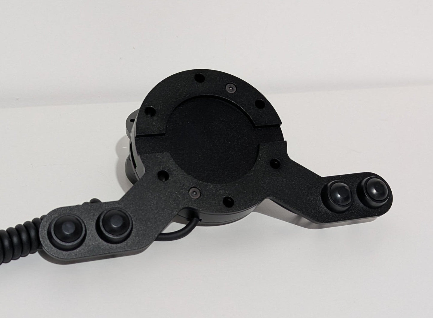 Front view of the JC wheel hub without the JC front plate The wheel hub has a bottom 4 button bracket with black buttons mounted.  The hub has a black coiled cable.