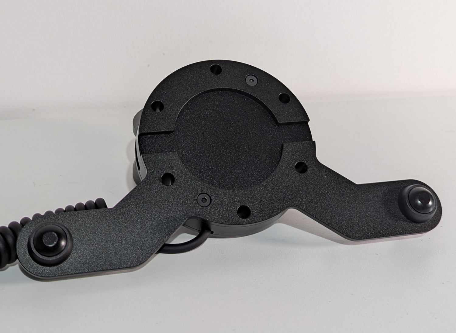 Front view of the JC wheel hub without the JC front plate The wheel hub has a bottom 2 button bracket with black buttons mounted.  The hub has a black coiled cable.